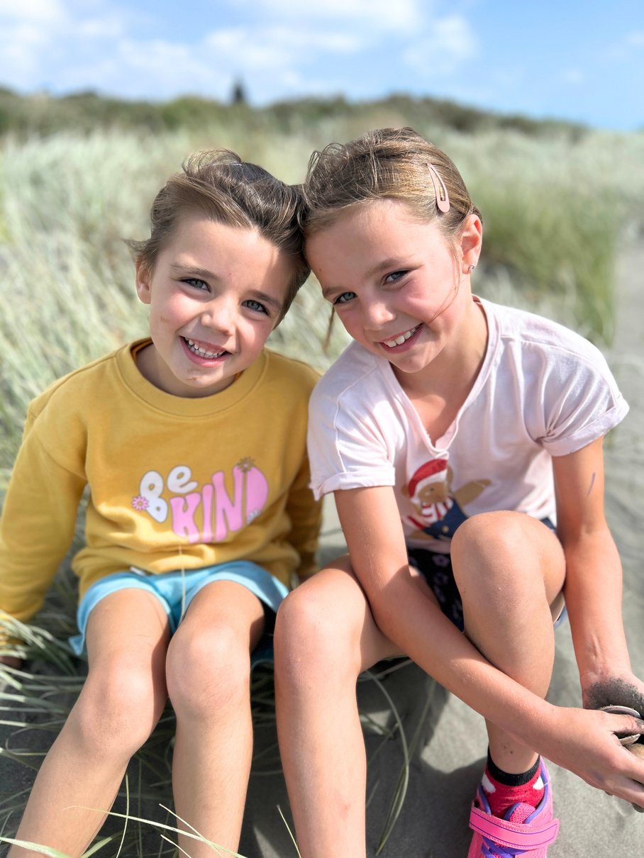 Jayne's two daughters sitting on the beach